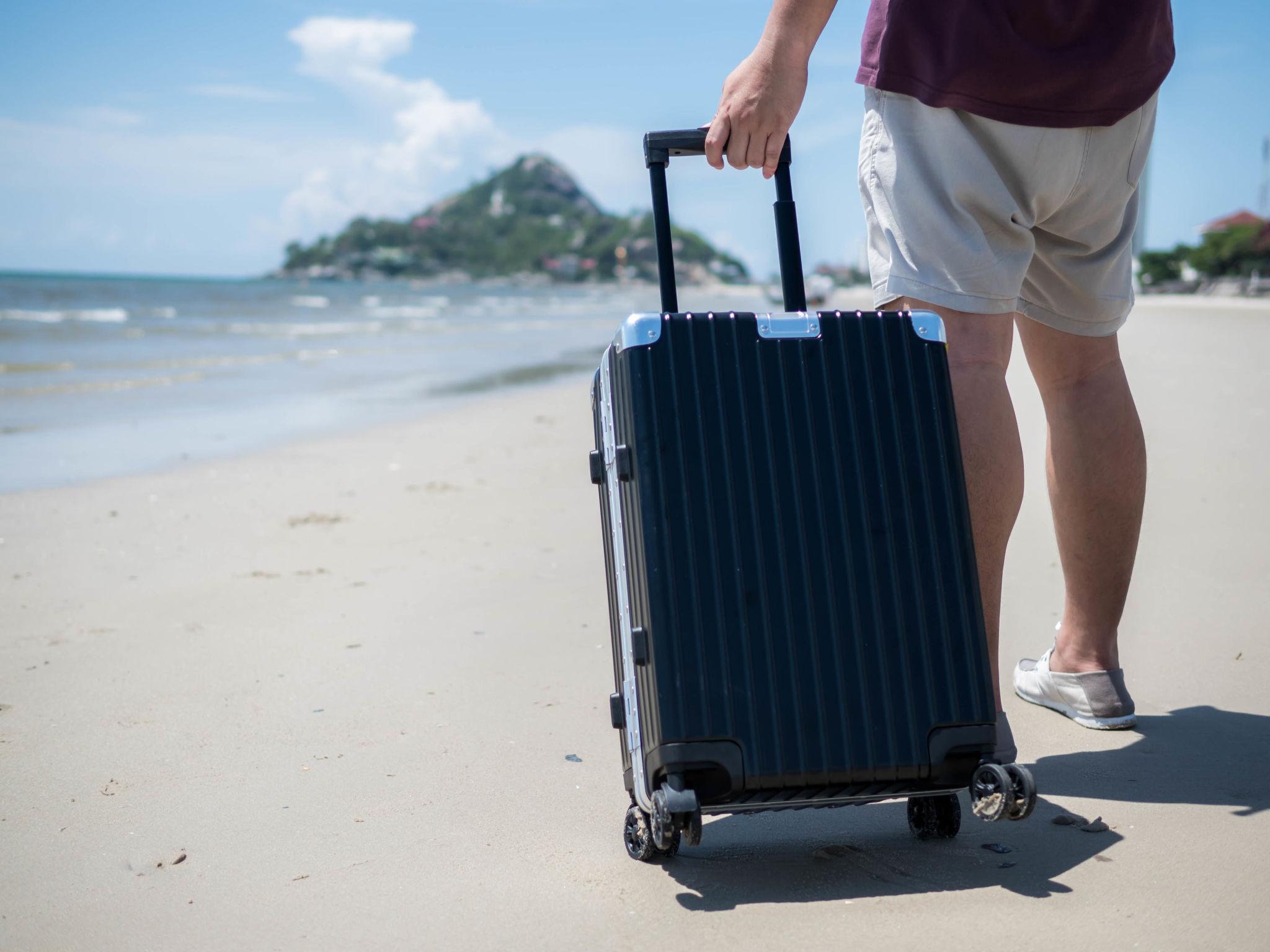 Traveler carrying a heavy hard-case suitcase during an Andaman trip